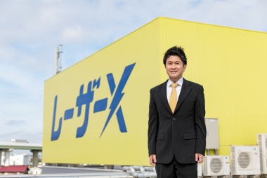 社屋前に立つ社長