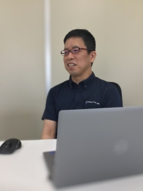 実験設備の前の中村さん